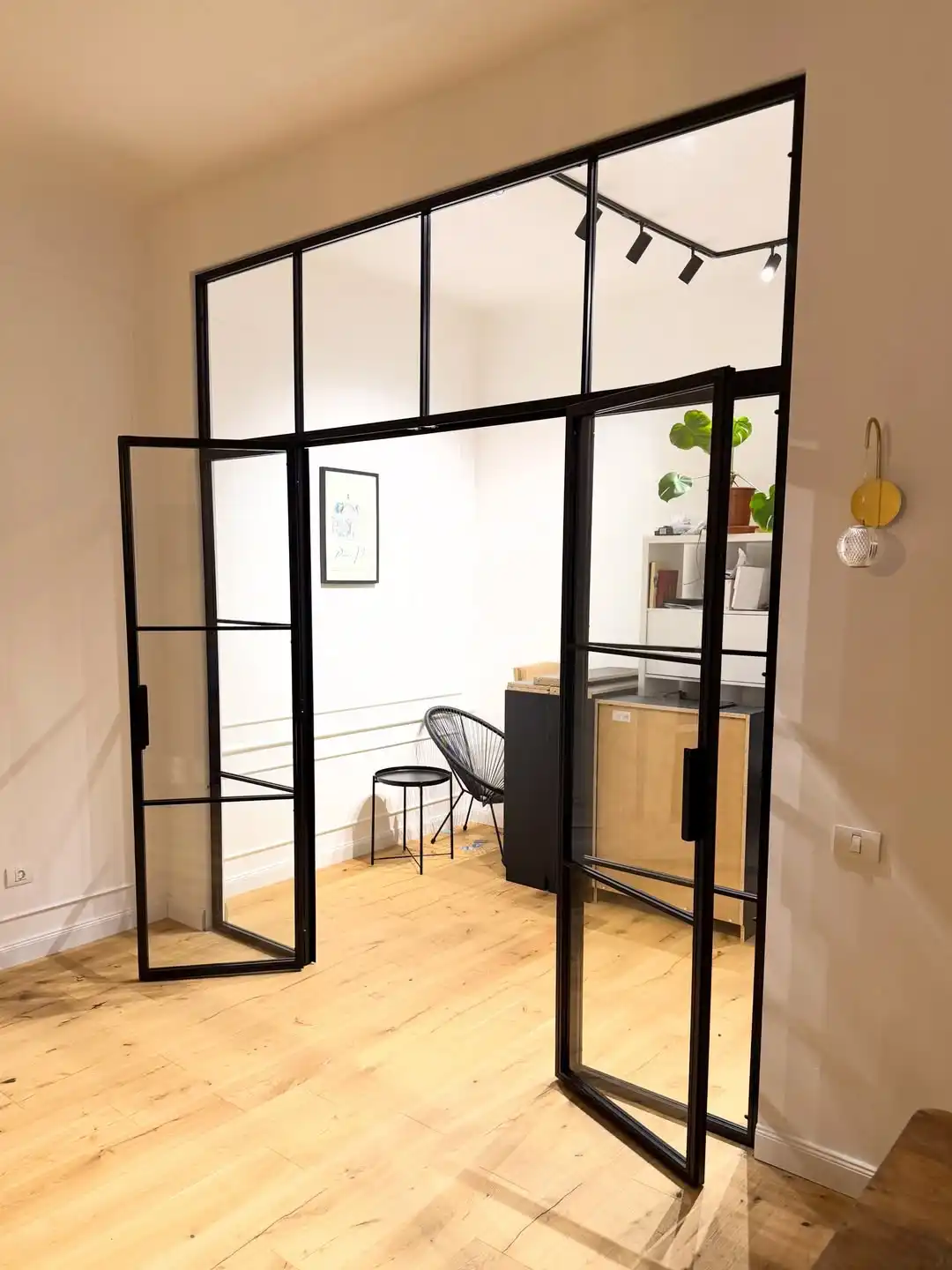 Glasvand tip loft cu ușă dublă deschisă între living și birou