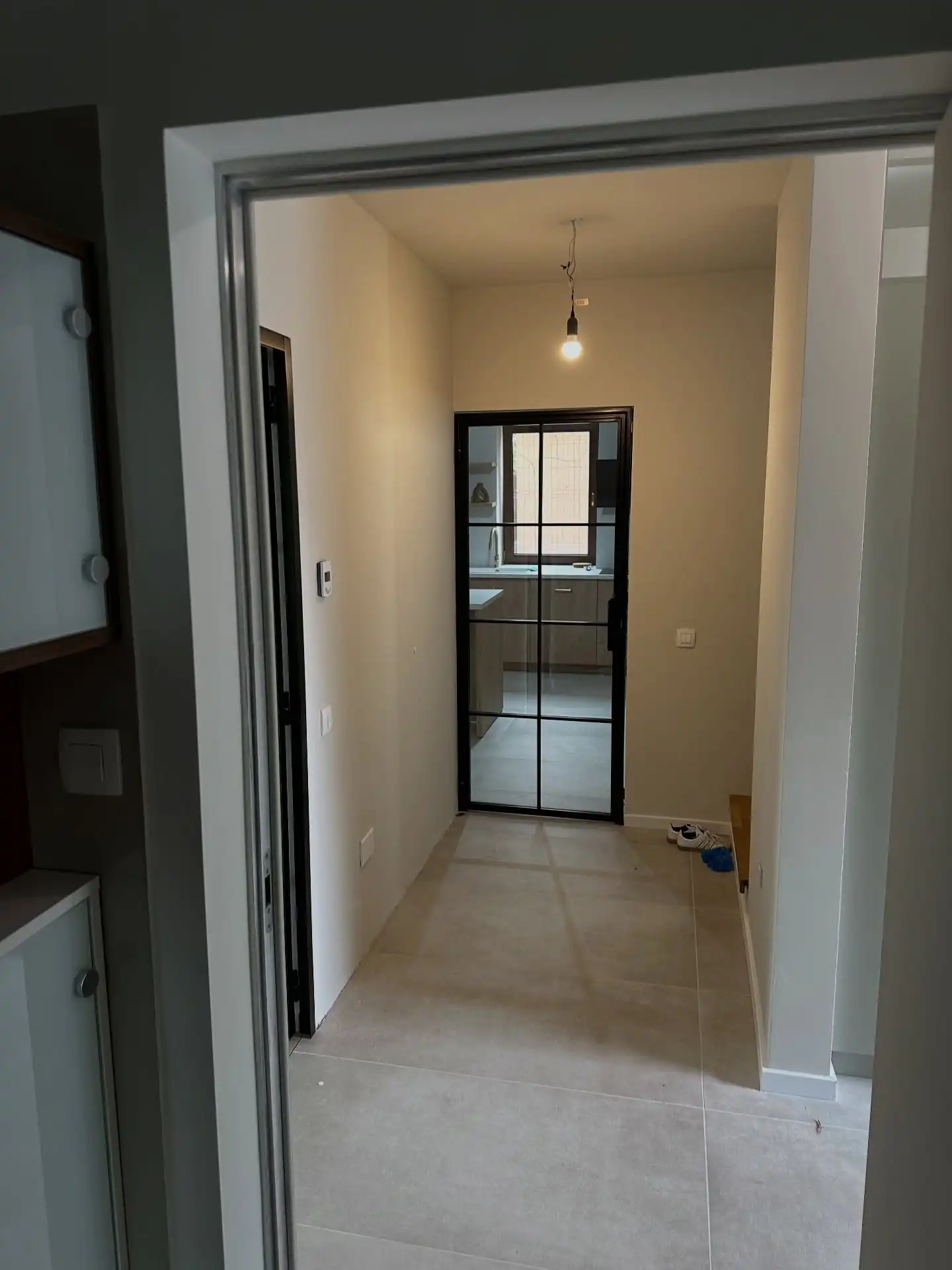 Hol cu ușă tip loft la capăt, privit dintr-o cameră